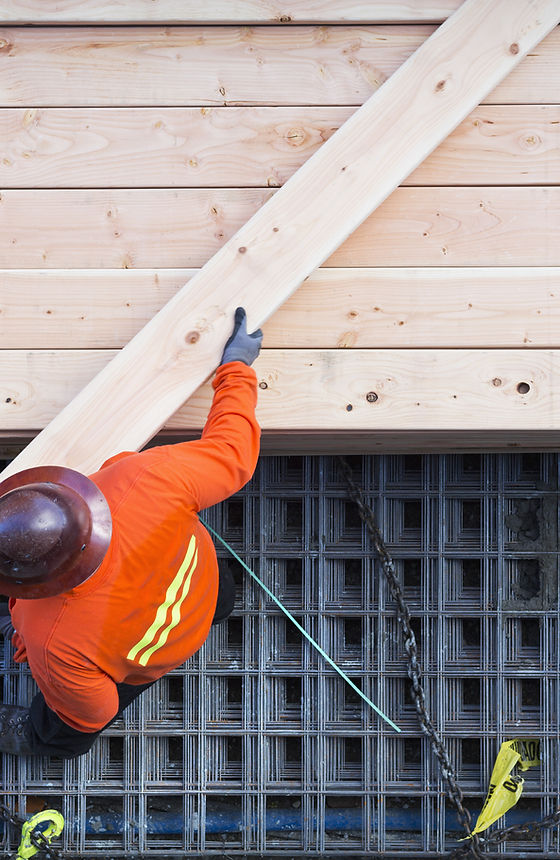 Construction Worker Lifting Wood Board